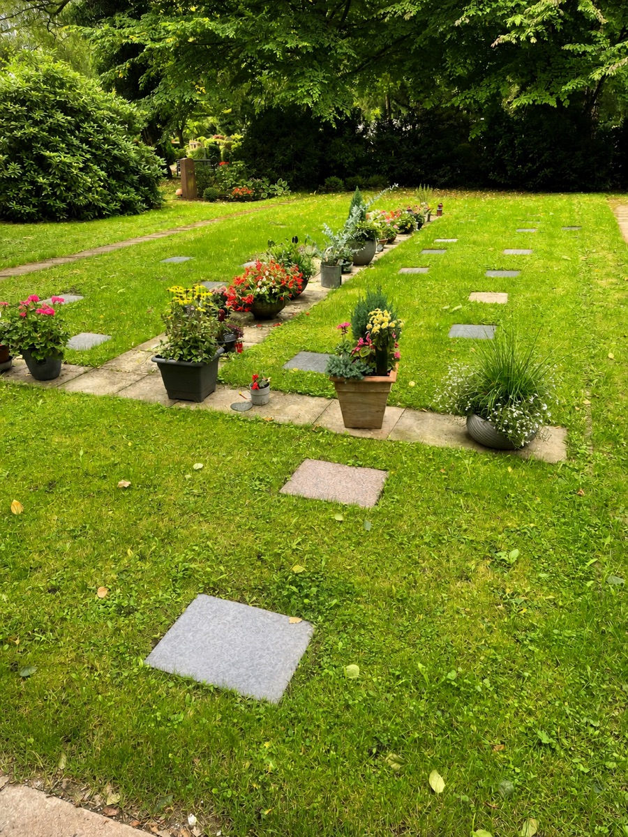 Rasenfläche mit Grabplatten und gemeinsamer Blumenablage